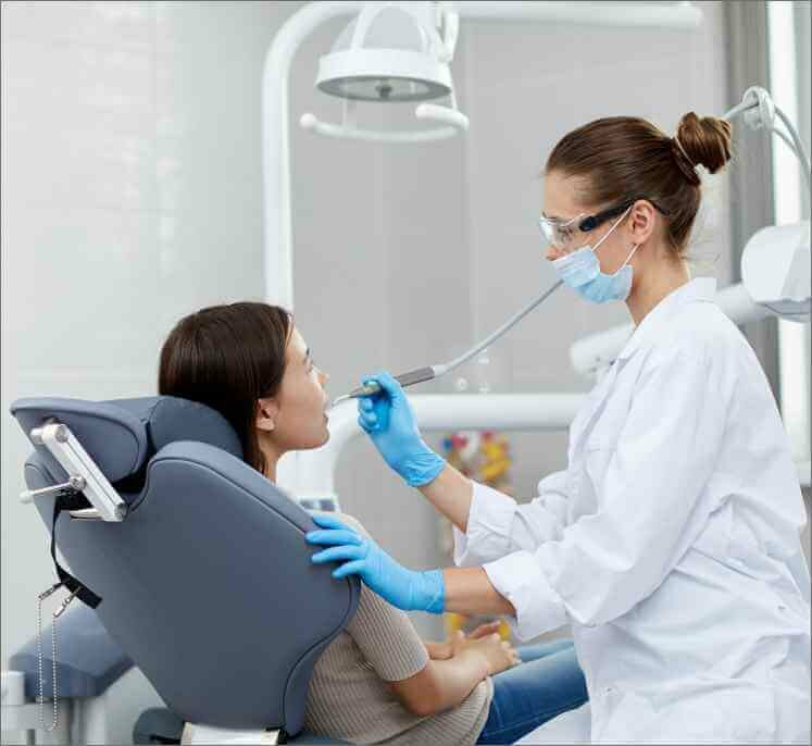 patient getting her teeth checked by a dentist in dallas, tx